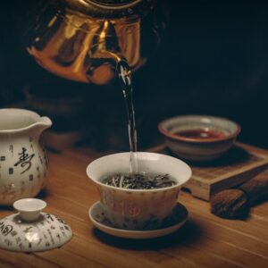 Artistic depiction of a traditional Chinese tea ceremony with porcelain teaware and hot water pour.